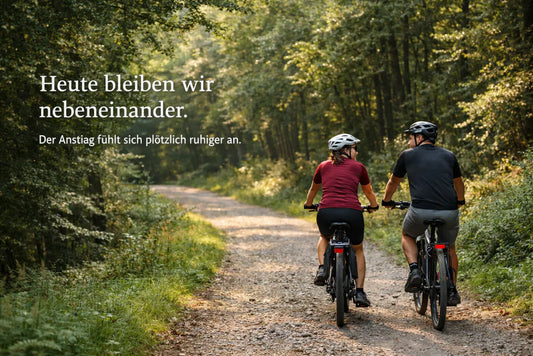 Paar fährt gemeinsam auf E-Bikes durch einen Waldweg – entspannte Fahrradtour für Paare und Familien