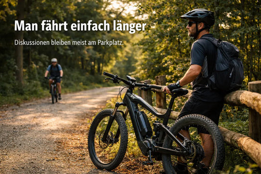 E-Bike Fahrer macht Pause am Waldweg während ein anderer Radfahrer vorbeifährt – typische Situation auf einer längeren E-Bike Tour