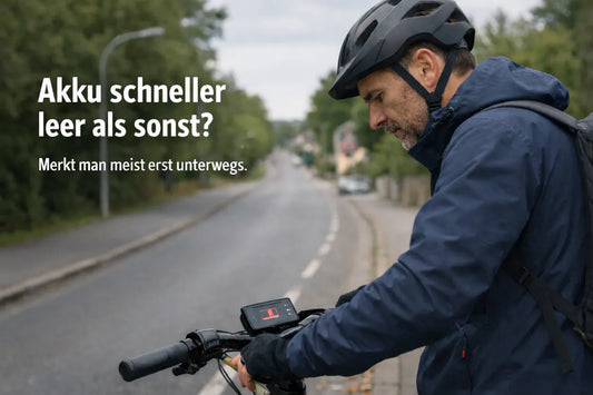 E-Bike Fahrer schaut auf Akku-Display während der Fahrt – Reichweite plötzlich schneller leer
