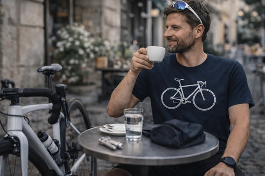 Rennradfahrer sitzt nach der Ausfahrt im Café und trägt navy T-Shirt mit „ICH BIN DER MOTOR“ Roadbike-Design – Geschenkidee für Roadies.