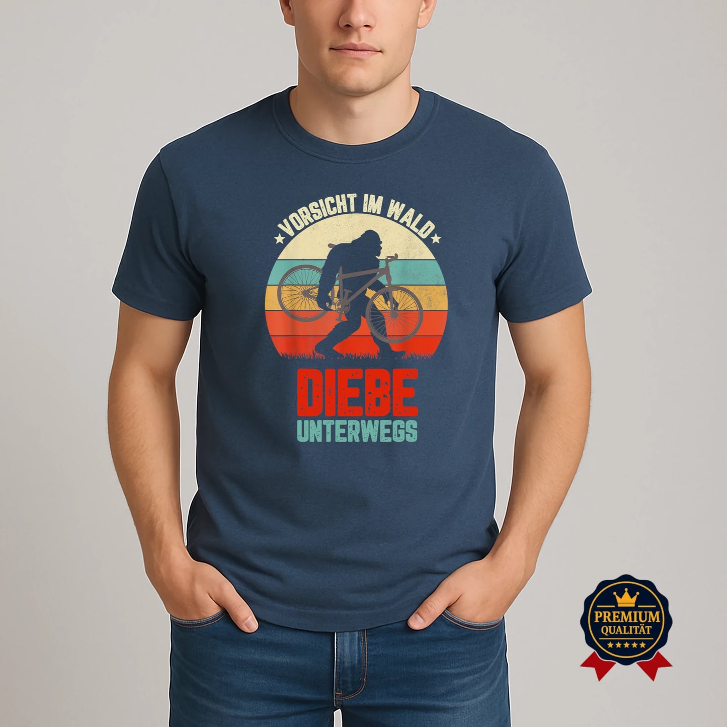 Model trägt dunkelblaues Fahrrad-T-Shirt mit Retro-Motiv ‚Vorsicht im Wald – Diebe unterwegs‘ und Bigfoot-Silhouette mit Fahrrad