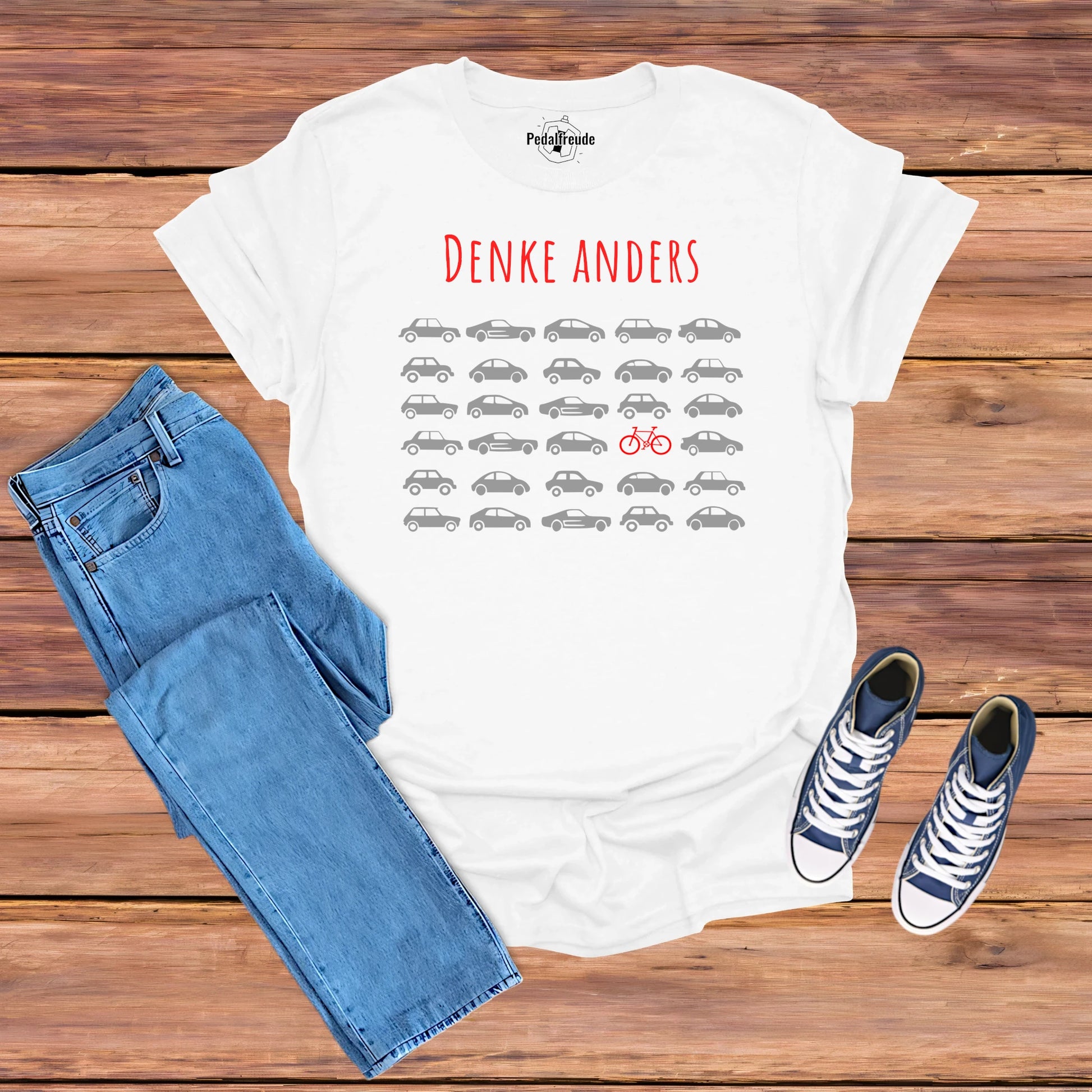 Weißes T-Shirt mit dem Design „Denke anders“ – Ein rotes Fahrrad zwischen grauen Autos, symbolisiert alternative Denkweise und Fahrradkultur.