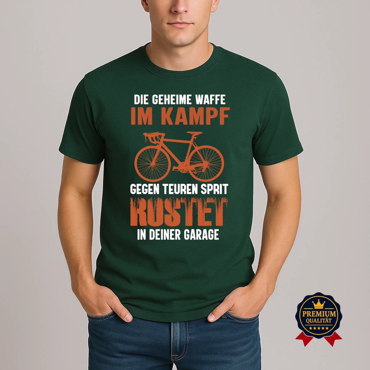 Grünes Rundhals-T-Shirt mit Fahrrad-Design und witzigem Sprit-Spar-Statement 'Die geheime Waffe im Kampf gegen teuren Sprit – rostet in deiner Garage', getragen von Model.