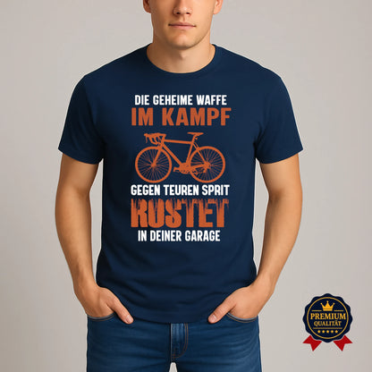 Dunkelblaues Rundhals-T-Shirt mit humorvollem Fahrrad-Design und Statement 'Die geheime Waffe im Kampf gegen teuren Sprit – rostet in deiner Garage', getragen von Model.