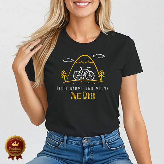 Schwarzes Damen Fahrrad T-Shirt mit gelbem Linienmotiv von Bergen, Bäumen und Fahrrad – Text: „Berge, Bäume und meine zwei Räder