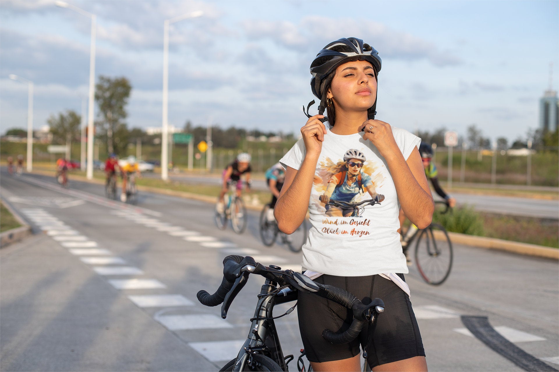 Fahrradfahrerin mit weißem T-Shirt „Wind im Gesicht, Glück im Herzen“ bei einer Tour – authentischer Lifestyle-Mockup für Radliebhaberinnen