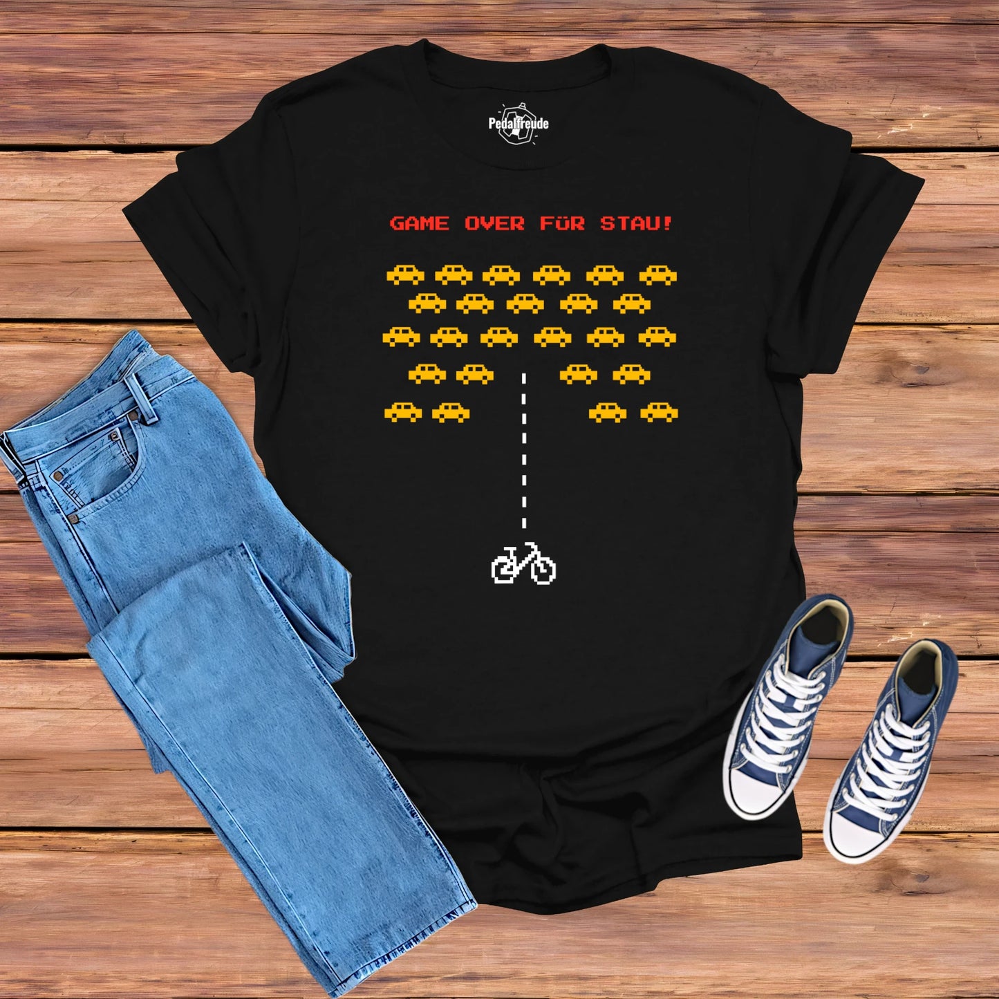 Hero Mockup eines schwarzen T-Shirts mit Pixel-Art Design "Game Over für Stau" – präsentiert mit Jeans und Sneakers.