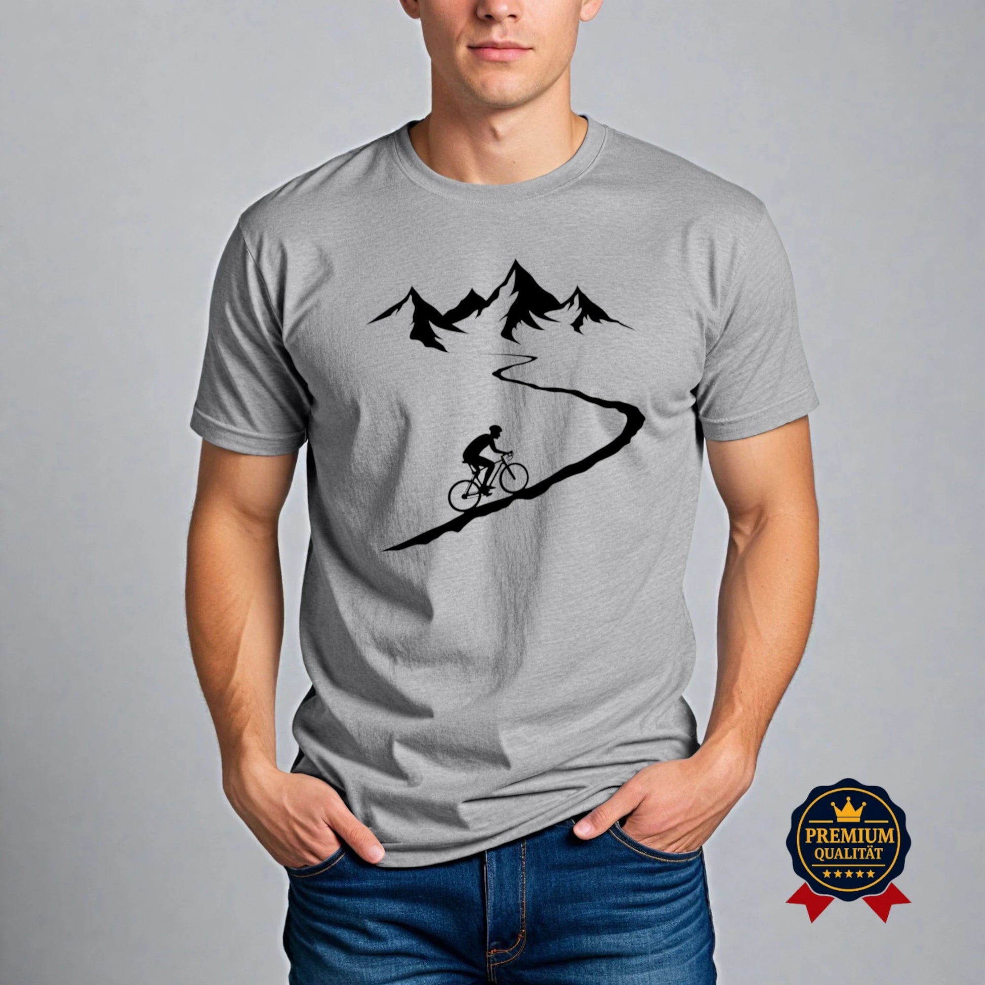 Graues Fahrrad T-Shirt mit Radfahrer auf kurviger Bergstraße und Alpenmotiv – Premium Bio-Shirt getragen von Mann im Casual Outfit