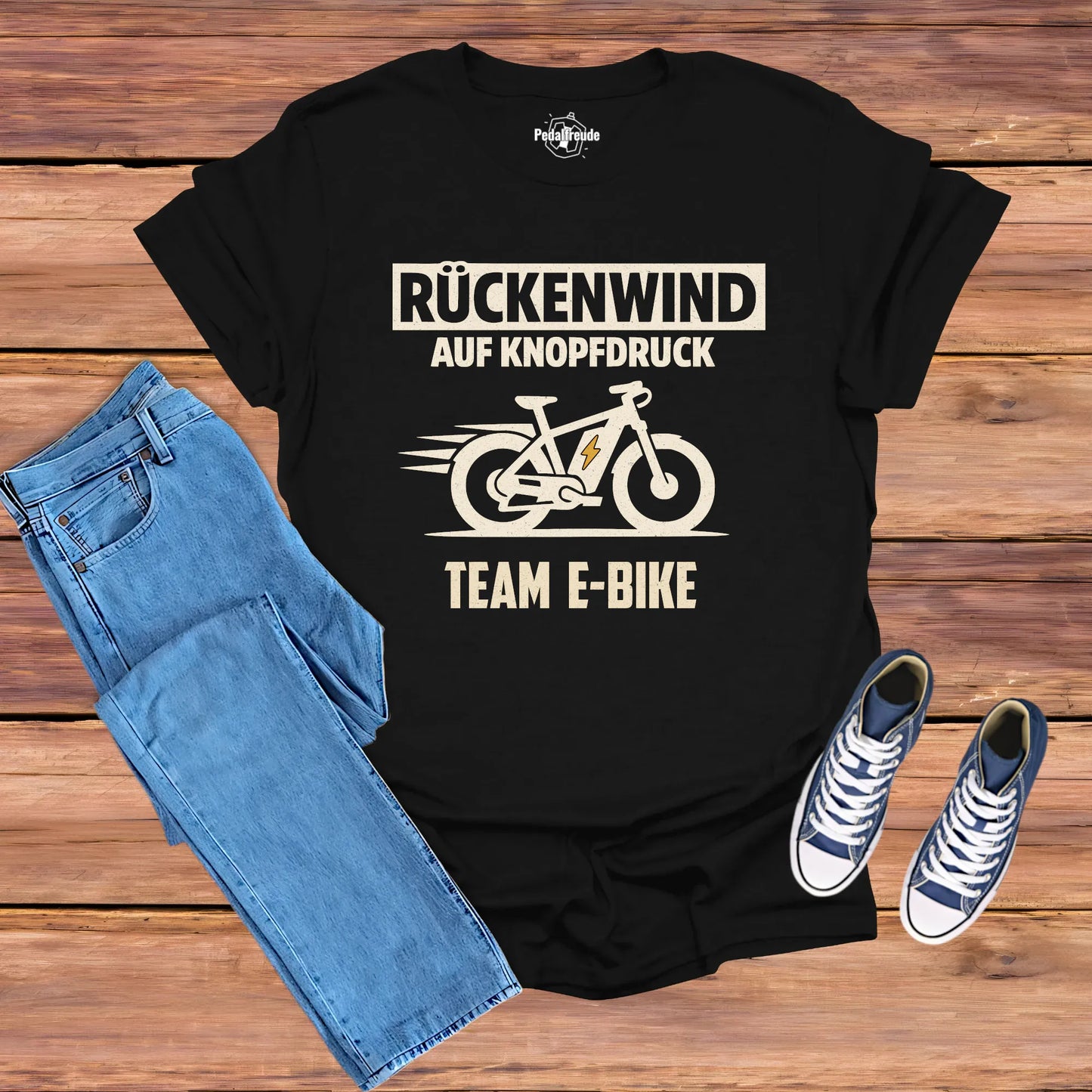 Flatlay: Schwarzes E-Bike T-Shirt „Rückenwind auf Knopfdruck – Team E-Bike“ im Vintage-Look (Pedalfreude)