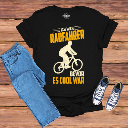 Schwarzes T-Shirt mit dem Spruch 'Ich war Radfahrer bevor es cool war' und Retro-Radfahrer-Design – präsentiert mit Jeans und Sneakers.