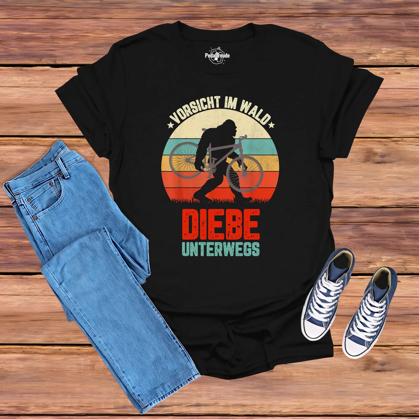 Schwarzes Fahrrad-T-Shirt mit Retro-Motiv „Vorsicht im Wald – Diebe unterwegs“, Bigfoot-Silhouette trägt ein Fahrrad, für Mountainbike- und Outdoor-Fans.