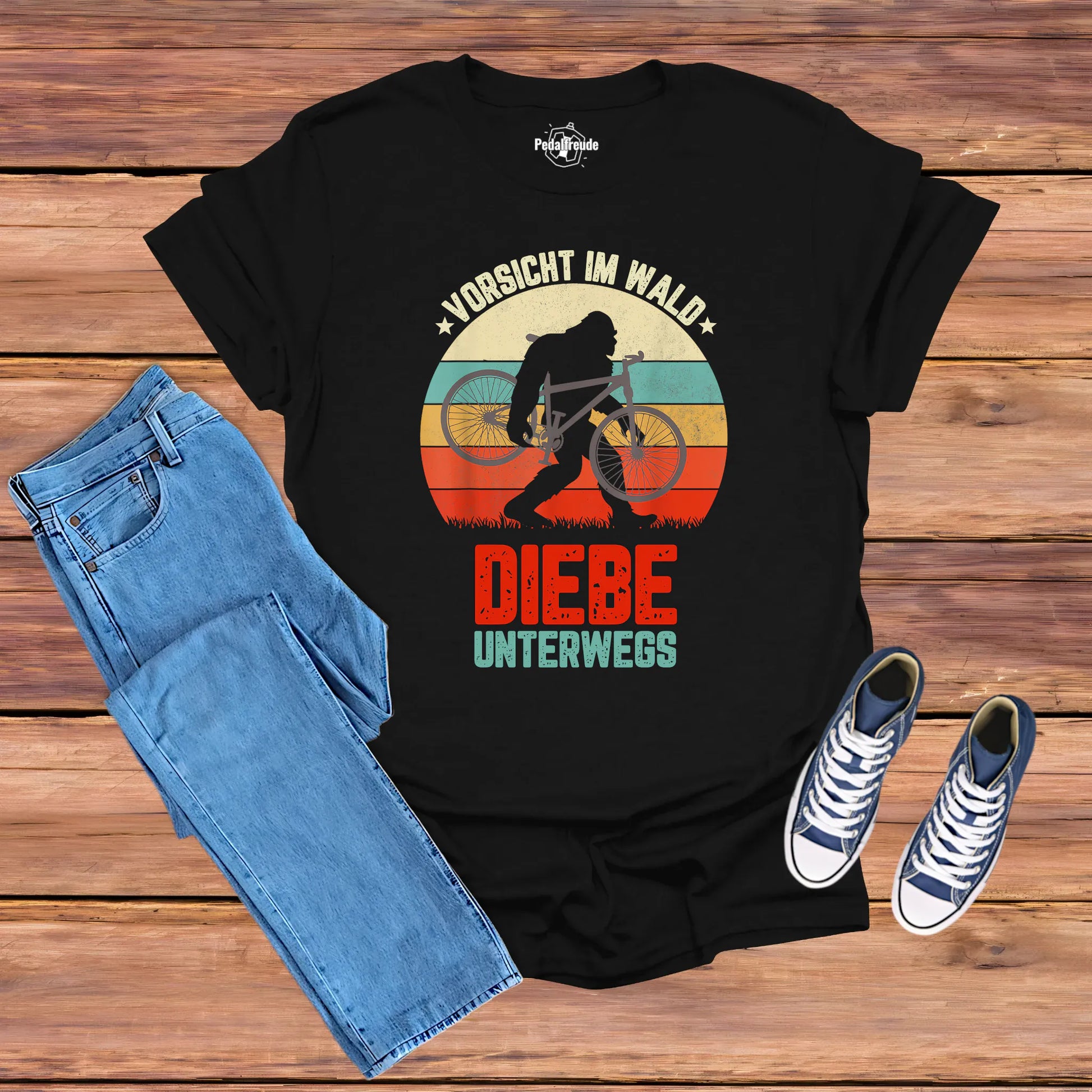 Schwarzes Fahrrad-T-Shirt mit Retro-Motiv „Vorsicht im Wald – Diebe unterwegs“, Bigfoot-Silhouette trägt ein Fahrrad, für Mountainbike- und Outdoor-Fans.